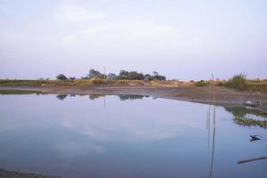 arial visie kanaal met groen gras en vegetatie weerspiegeld in de water dichtbij padma rivier- in Bangladesh foto