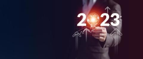 zakenman Holding licht lamp concept van de nieuw jaar 2023 met nieuw creatief ideeën, bedrijf financieel en innovatie technologie doelen en planning voor De volgende jaar 2023 foto