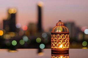 gouden lantaarns met dageraad lucht en stad bokeh licht achtergrond voor de moslim feest van de heilig maand van Ramadan kareem. foto