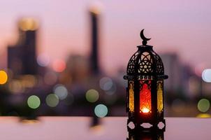 lantaarn met schemer lucht en stad bokeh licht achtergrond voor de moslim feest van de heilig maand van Ramadan kareem. foto