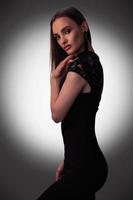 sexy jong dame in zwart jurk in studio foto
