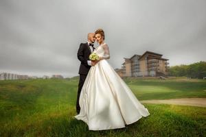 aantrekkelijk jong elegant merried paar knuffelen buitenshuis foto