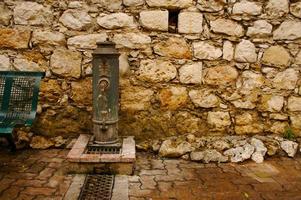 oude steen muur en water pomp foto