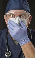 verbijsterd dokter of verpleegster met beschermend slijtage en stethoscoop foto