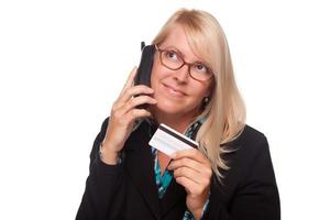 mooi blond vrouw met telefoon en credit kaart foto