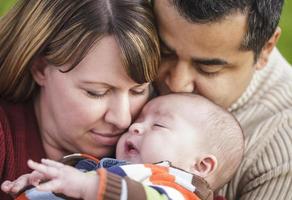 gelukkig gemengd ras ouders knuffelen hun zoon foto