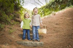 twee kinderen wandelen naar beneden hout stappen met mand buiten. foto