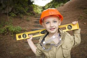 aanbiddelijk kind jongen met niveau spelen klusjesman buiten foto