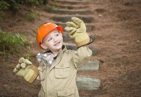 schattig kind jongen met grote handschoenen spelen klusjesman buiten foto