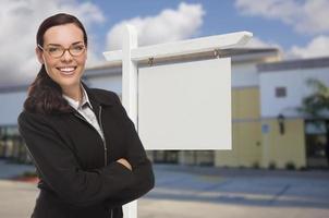 vrouw in voorkant reclame gebouw en blanco echt landgoed teken foto