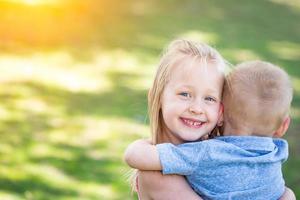 jong broer en zus knuffelen Bij de park foto