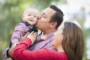 weinig baby jongen hebben pret met moeder en vader buitenshuis foto