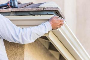 arbeider Vastmaken aluminium regen goot naar bindweefsel van huis foto