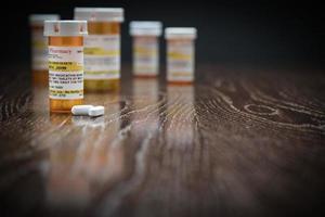 verscheidenheid van niet-eigendom voorschrift geneeskunde flessen en pillen Aan reflecterende houten oppervlak. foto