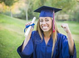 expressief jong vrouw Holding diploma in pet en japon foto