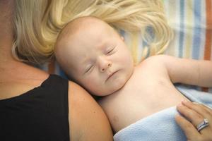 schattig baby jongen houdende De volgende naar zijn mama Aan deken foto