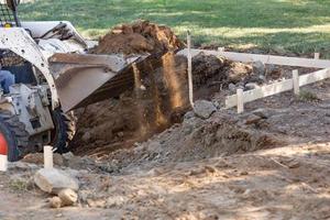 klein bulldozer graven in werf voor zwembad installatie foto