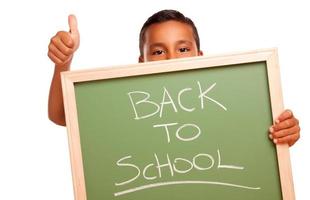 schattig spaans jongen Holding schoolbord met terug naar school- foto