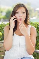 geschokt jong volwassen vrouw pratend Aan cel telefoon buitenshuis foto