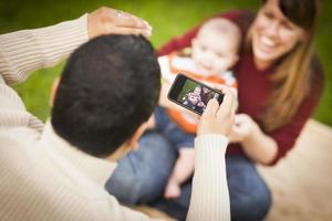 gelukkig gemengd ras ouders en baby jongen nemen zelf portretten foto