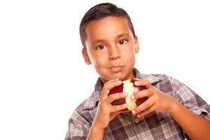 aanbiddelijk spaans jongen aan het eten een groot rood appel foto