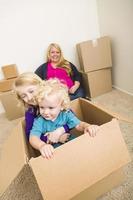 jong familie in leeg kamer spelen met in beweging dozen foto