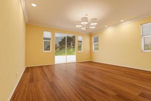 nieuw verbouwd kamer van huis met afgewerkt hout vloeren, vormen, licht geel verf en plafond lichten. foto