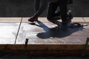 bouw arbeider gladmaken nat cement met hand- edger gereedschap foto
