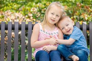 jong zus en broer hebben pret Aan de bank Bij de park foto