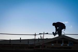 bouw arbeiders silhouet Aan dak van gebouw foto
