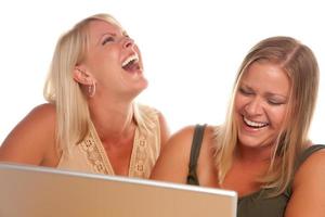 twee lachend Dames gebruik makend van laptop foto