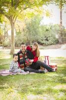 gemengd ras familie genieten van Kerstmis cadeaus in de park samen foto