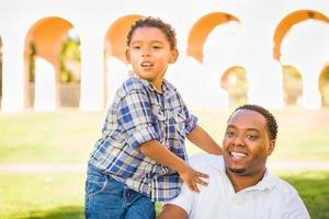 gelukkig Afrikaanse Amerikaans vader en gemengd ras zoon spelen Bij de park foto