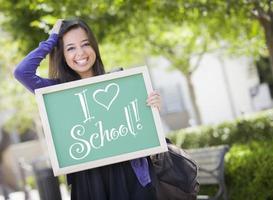 gemengd ras vrouw leerling Holding schoolbord met ik liefde school- foto