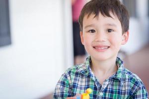 portret van gemengd ras Chinese en Kaukasisch jong jongen met speelgoed- foto