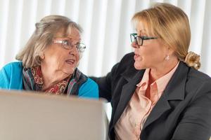 vrouw helpen senior volwassen dame Aan laptop computer foto