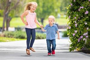 jong zus en broer Holding handen en rennen Bij de park foto