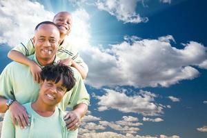 gelukkig Afrikaanse Amerikaans familie over- blauw lucht en wolken foto