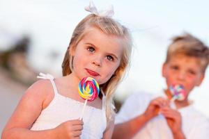 schattig weinig meisje en broer genieten van hun lolly foto