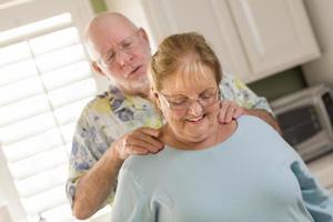 senior volwassen man geven vrouw een schouder wrijven foto