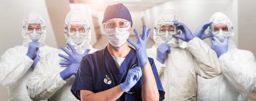 team van vrouw en mannetje artsen of verpleegsters vervelend persoonlijk beschermend uitrusting in ziekenhuis gang foto