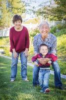 gelukkig Chinese grootouders hebben pret met hun gemengd ras kleinzoon buiten foto