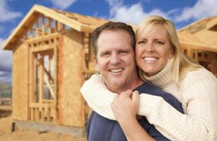 paar in voorkant van nieuw huis bouw framing plaats foto