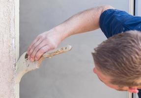 professioneel schilder snijdend in met borstel naar verf huis deur kader. foto