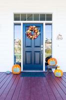 mooi huis veranda versierd voor halloween met pompoenen vervelend medisch gezicht maskers foto