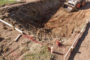 klein bulldozer graven in werf voor zwembad installatie foto