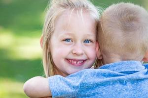 jong broer en zus knuffelen Bij de park foto