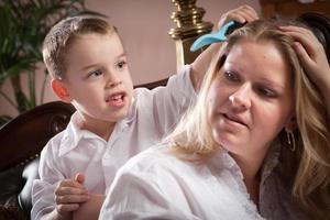 schattig zoon poetsen zijn mama's haar- foto