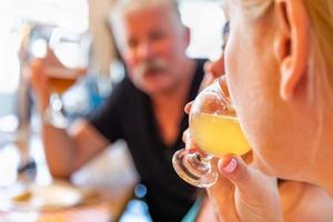 vrouw nippen glas van micro brouwen bier Bij bar met vrienden foto