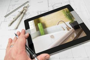 hand- van architect Aan computer tablet tonen badkamer details over- huis plannen foto
